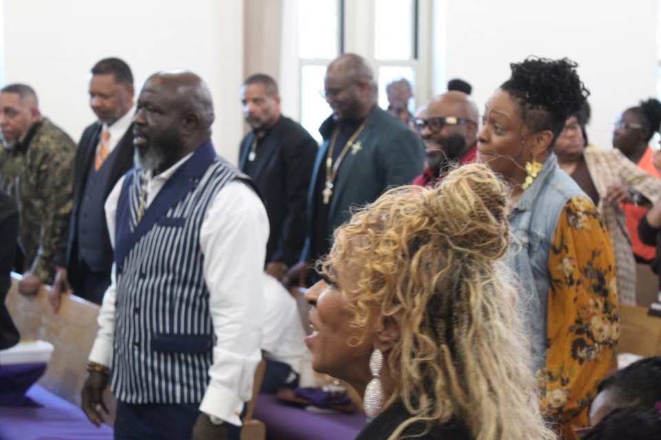 The saints standing together in worship